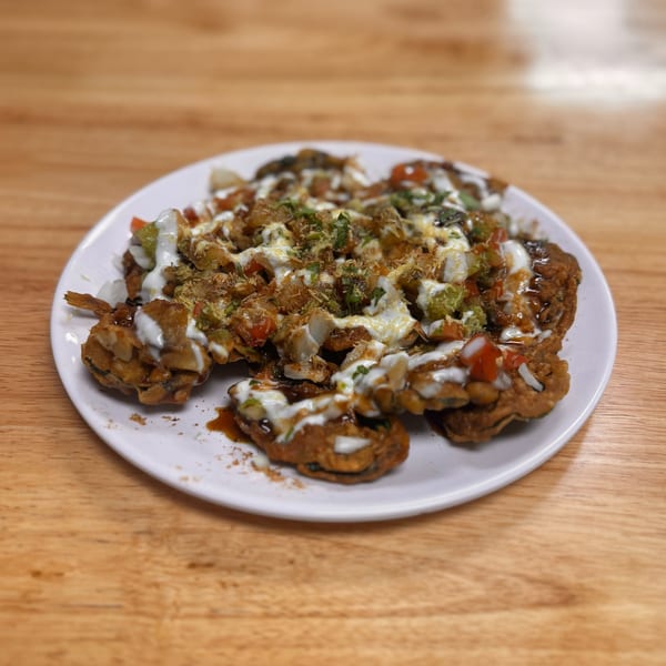 Crispy fried chaat topped with yogurt, chutneys, and fresh vegetables