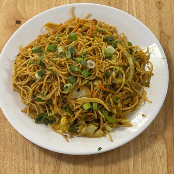 Vegetable hakka noodles with scallions and fresh herbs
